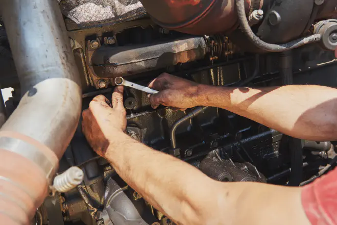  A mechanic replacing spark plugs in a car engine - Learn how long it takes to change spark plugs for optimal performance